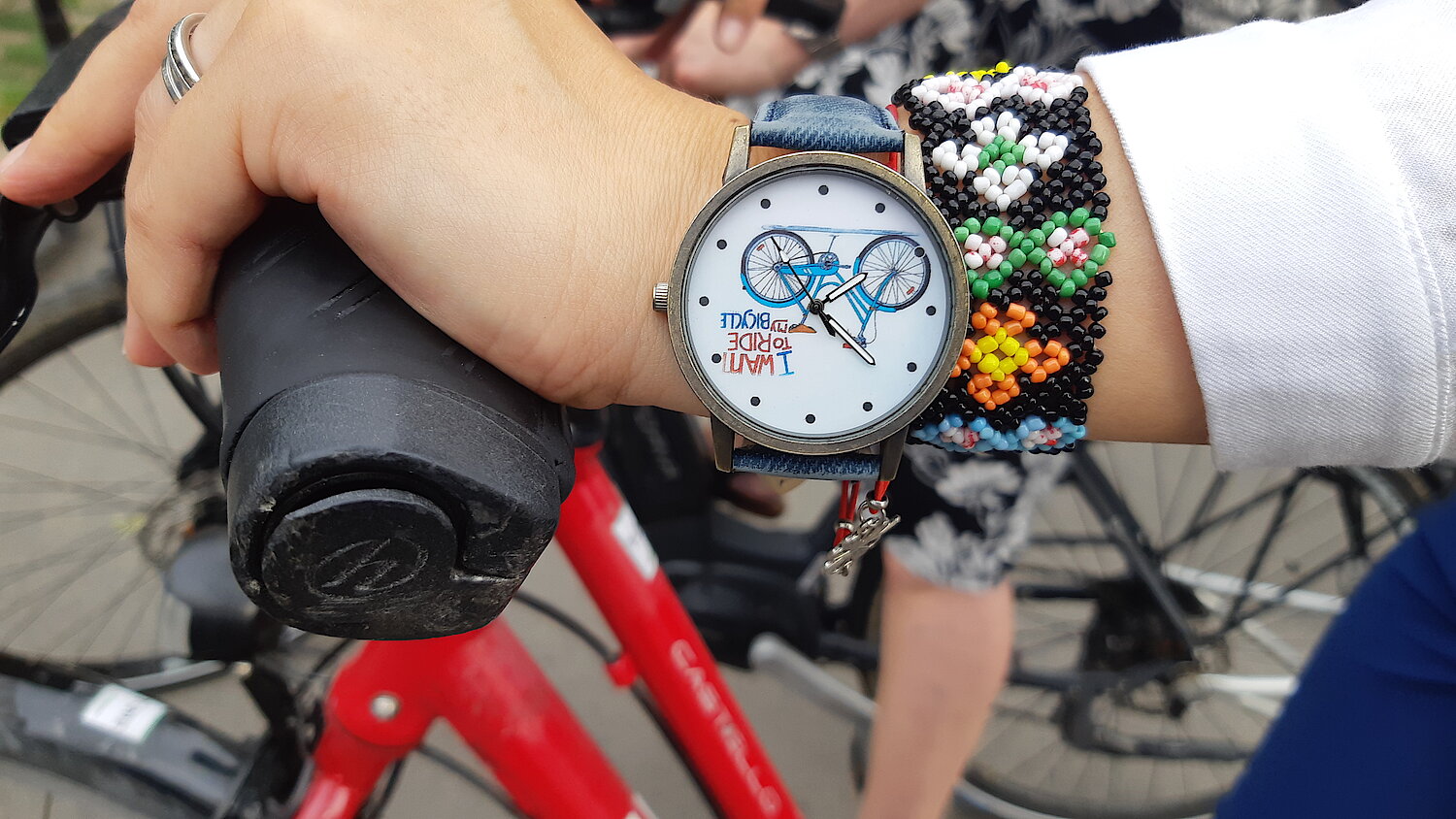 Hand mit Armbanduhr auf Fahrradlenker