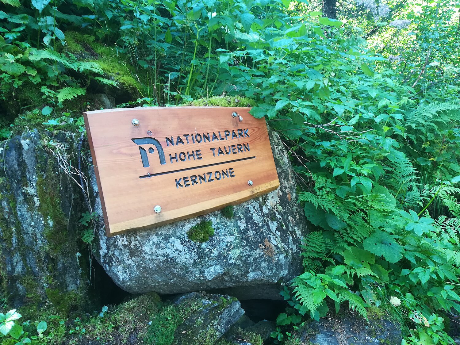 Tafel auf einem Felsen mit der Aufschrift: Nationalpark Hohe Tauern - Kernzone