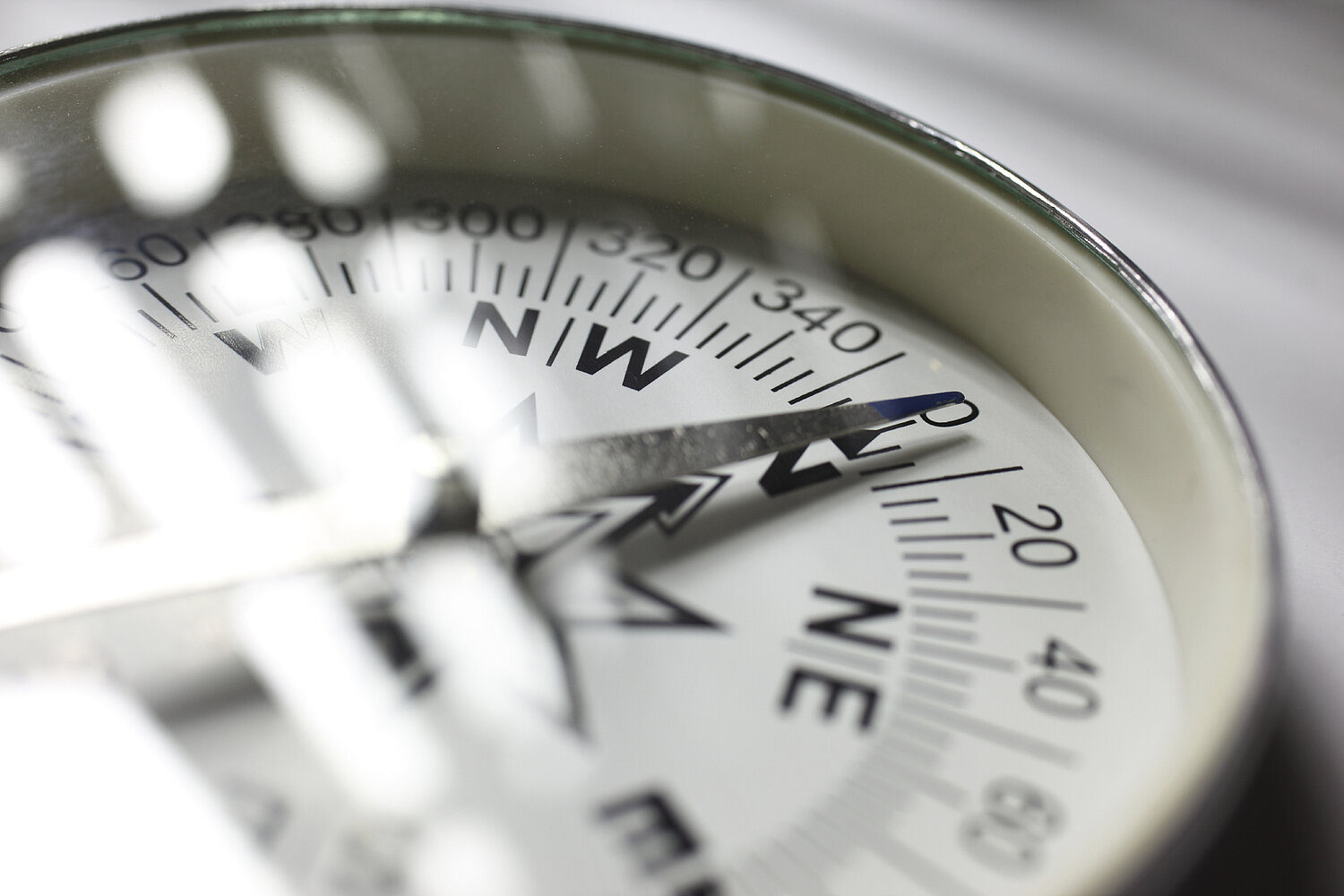 Das Bild zeigt einen Metallkompass im einfallenden Sonnenlicht von Nahe.