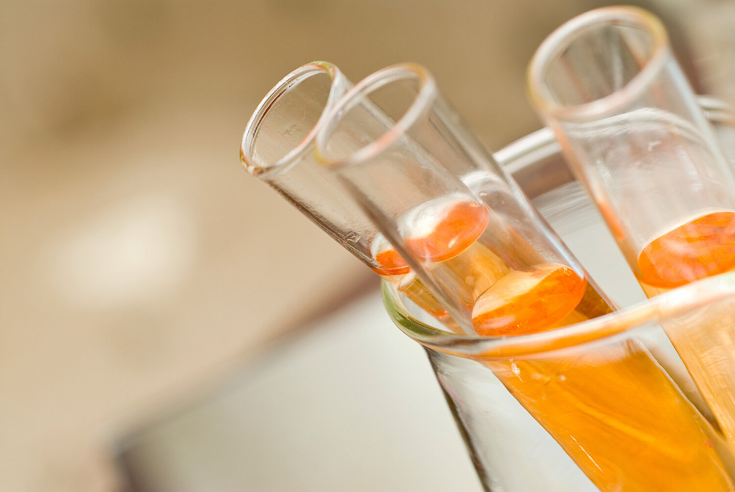 Foto Teströhrchen mit oranger Flüssigkeit