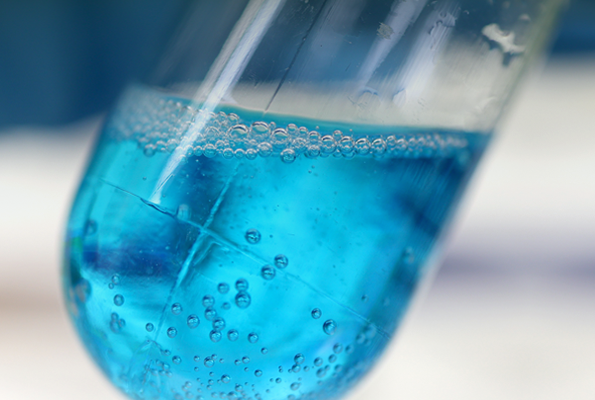 Blau leuchtende Flüssigkeit in einem Reagenzglas.