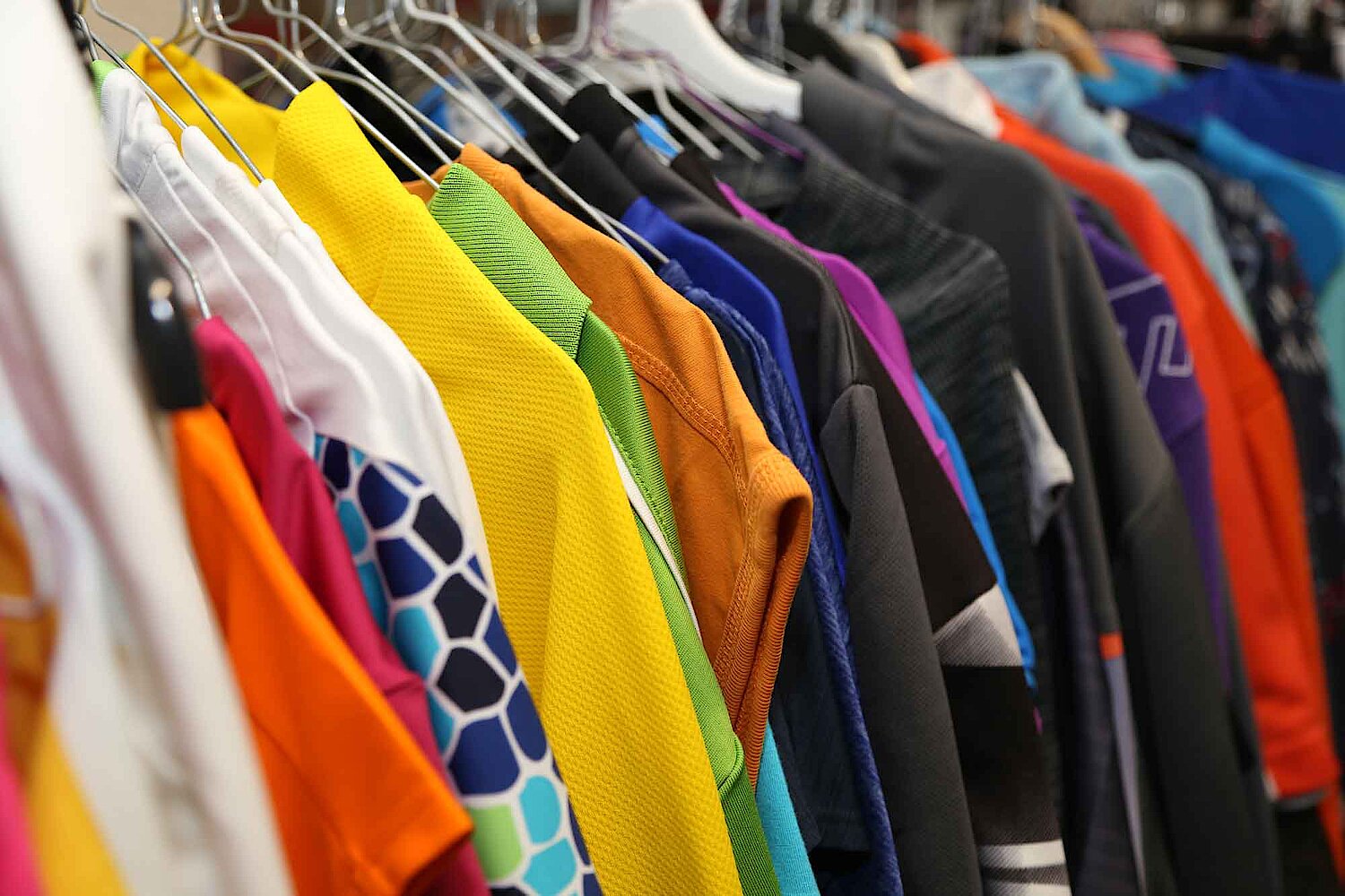 Foto bunte T-Shirts auf Kleiderbügeln in der Kleidersammlung