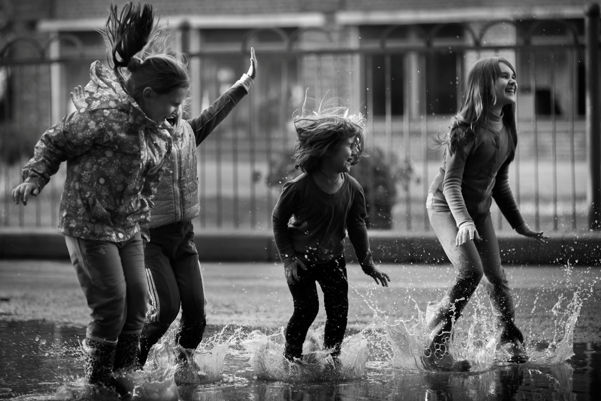 Kinder spielen in einer Wasserpfütze.