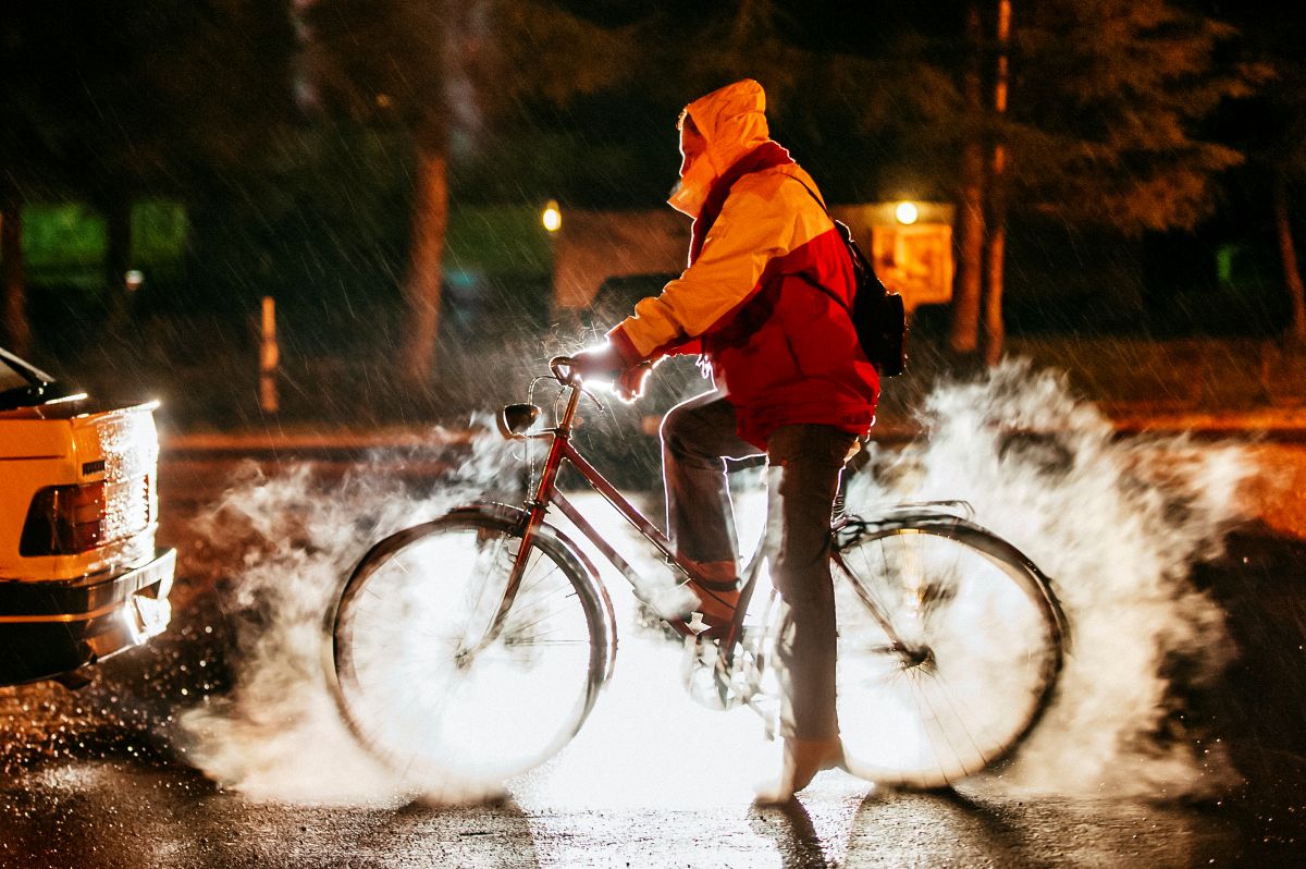 Radfahrer im Stau bei Nacht mitten in Abgasen.