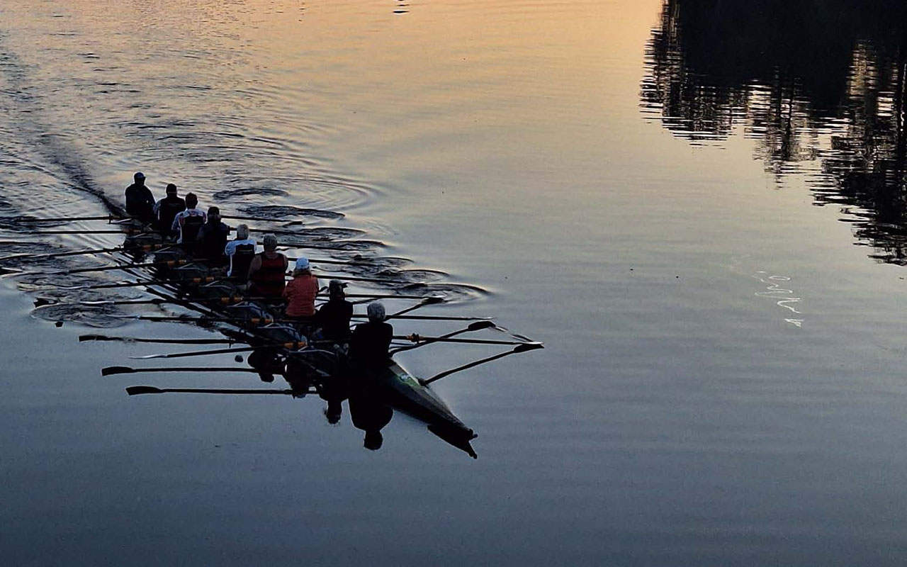 Ruderboot bei Sonnenuntergang auf einem Fluss.