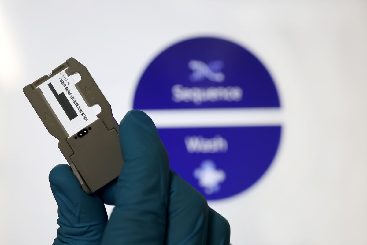 Hand in blauem Handschuh hält Computer-Chip.