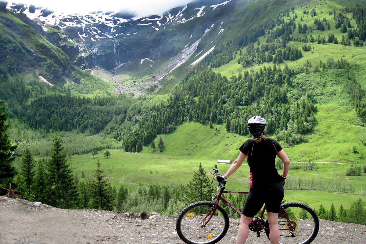 Frau mit Mountainbike mit Blick auf Gebirge