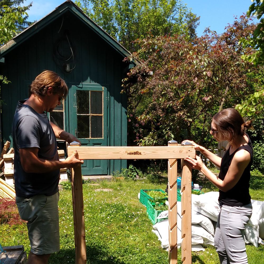 Foto von zwei Personen beim Bauen eines vertikalen Beetes 
