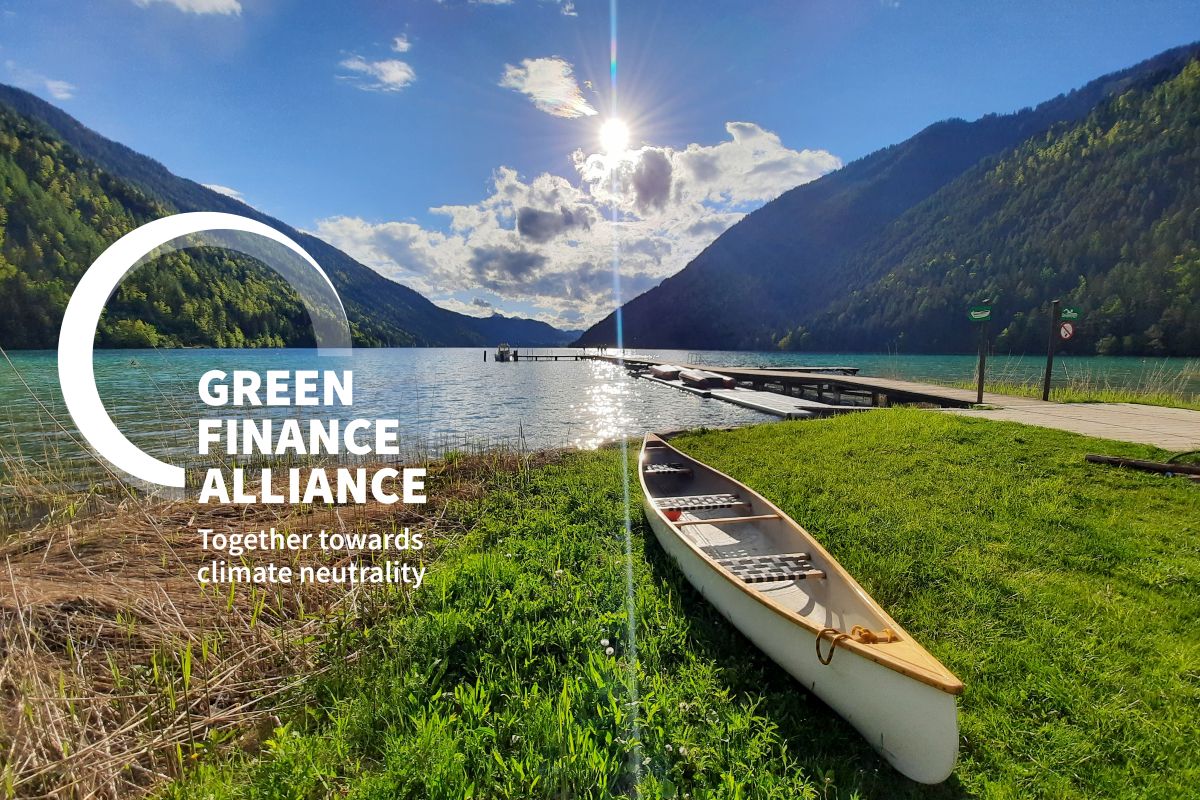 Boot am Ufer von einem See mit Bergen im Hintergrund im Sonnenlicht.